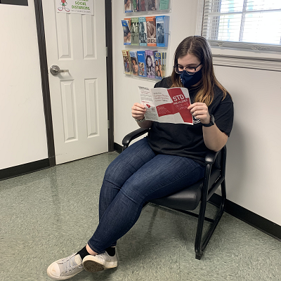 Student reading pamphlet in clinic