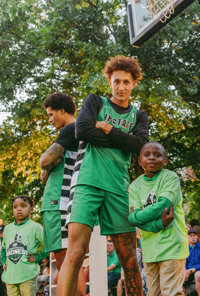 USC Upstate basketball player posing "fierce" with a child at Morgan Square Madness